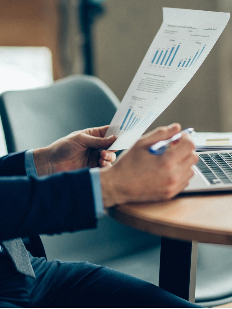 businessman holding a sheet of data and pen